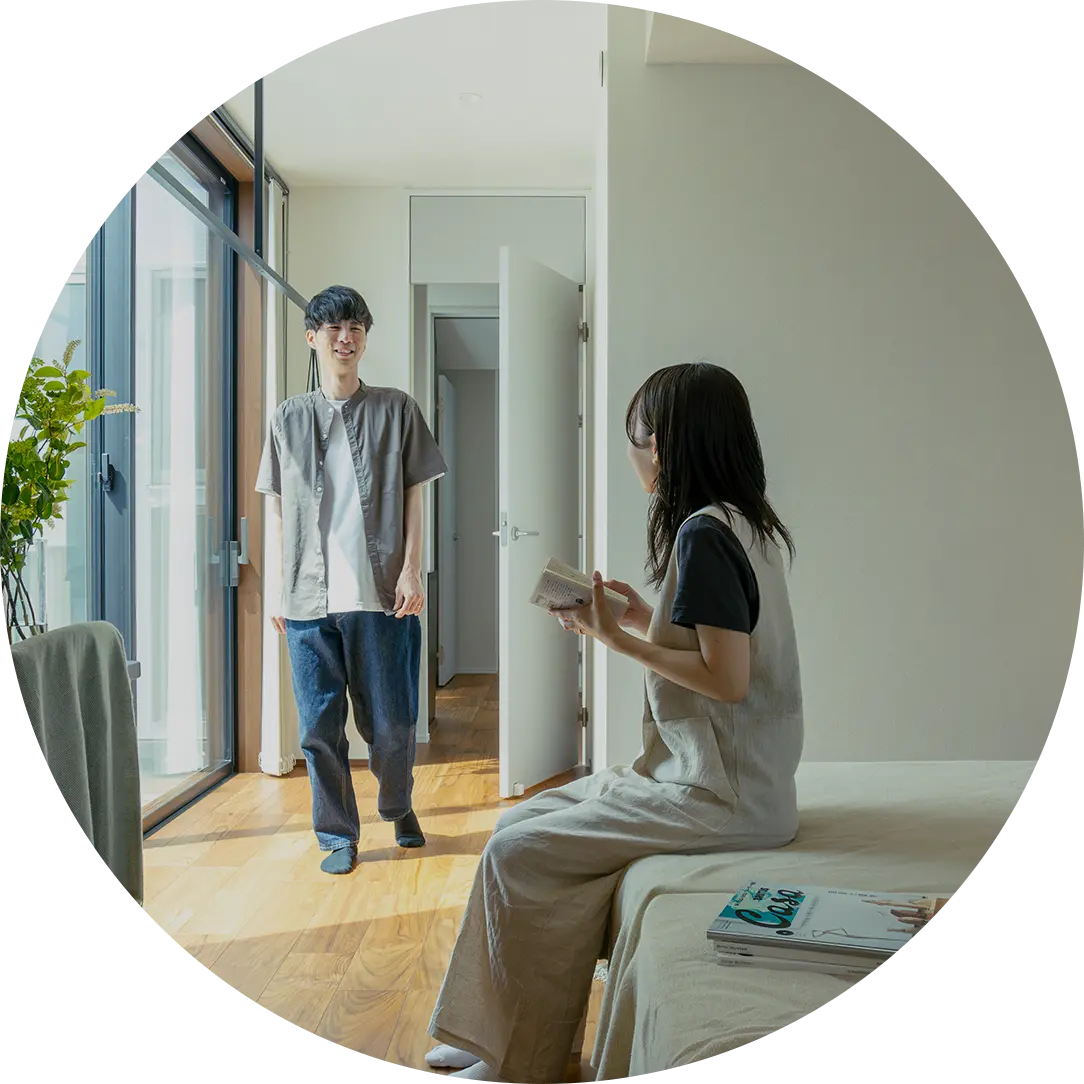 ダイニングテーブルで向かい合って微笑む若い夫婦